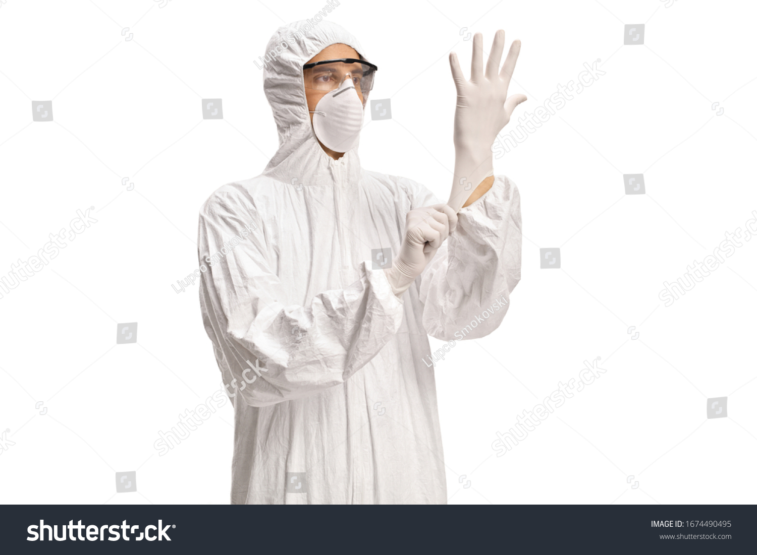 Man in a white decontamination suit putting on medical gloves isolated on white background #1674490495
