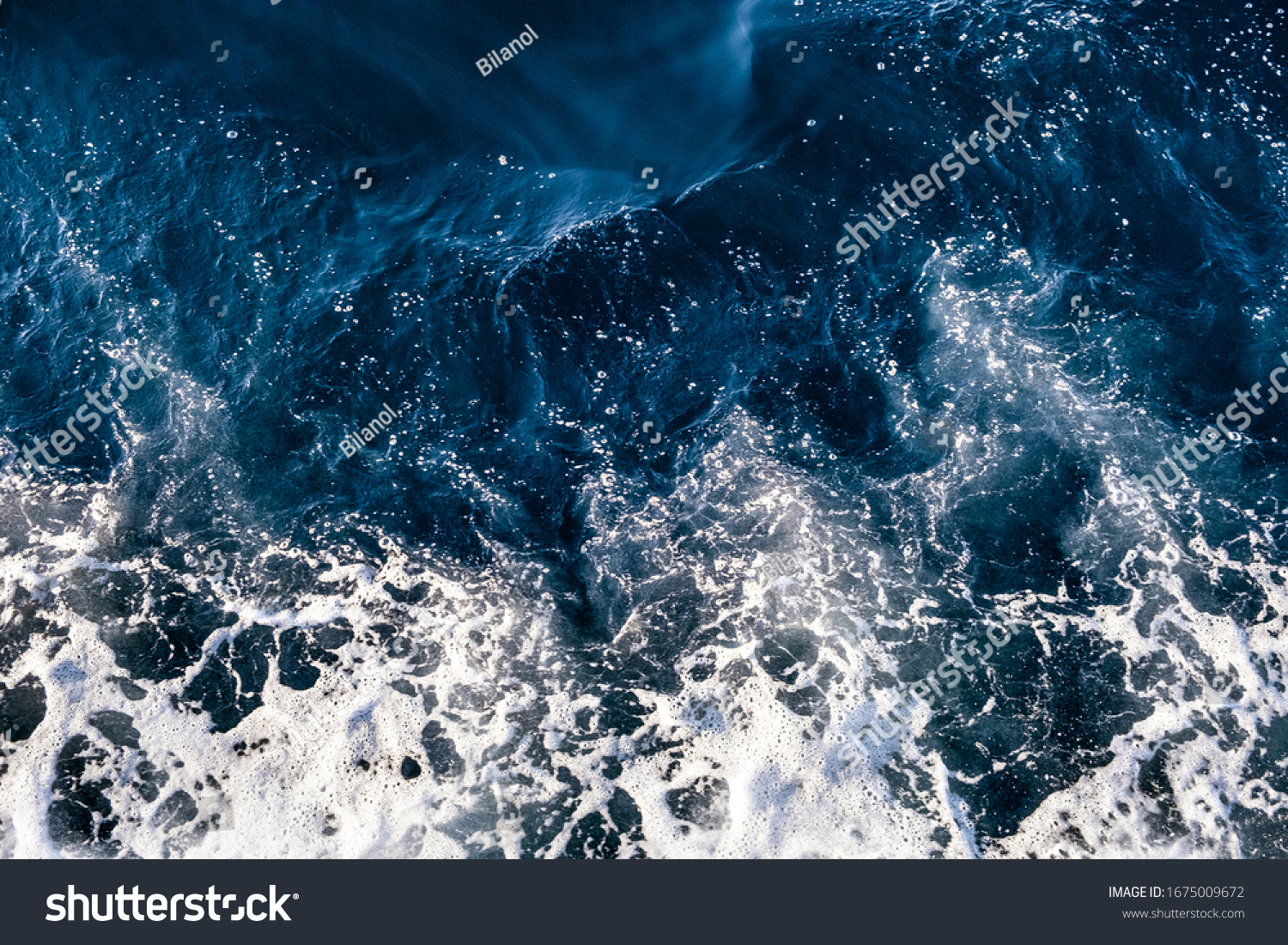 Top down aerial view of sea water surface. White foam waves texture as natural background. #1675009672