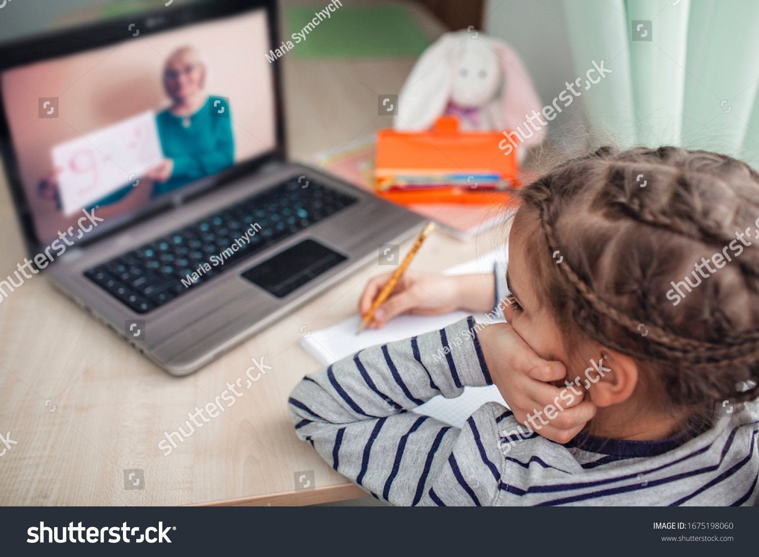 Pretty stylish schoolgirl studying homework math during her online lesson at home, social distance during quarantine, self-isolation, online education concept, home schooler