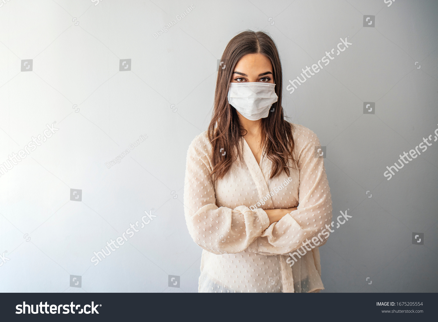 Beautiful young woman in white t-shirt with disposable face mask. Protection versus viruses and infection. Studio portrait, concept with gray background. Woman suffer from sick and wearing face mask. #1675205554