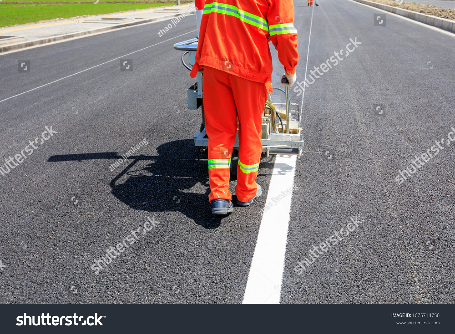 Road workers use hot-melt scribing machines to painting dividing line on asphalt road surface in the city. #1675714756