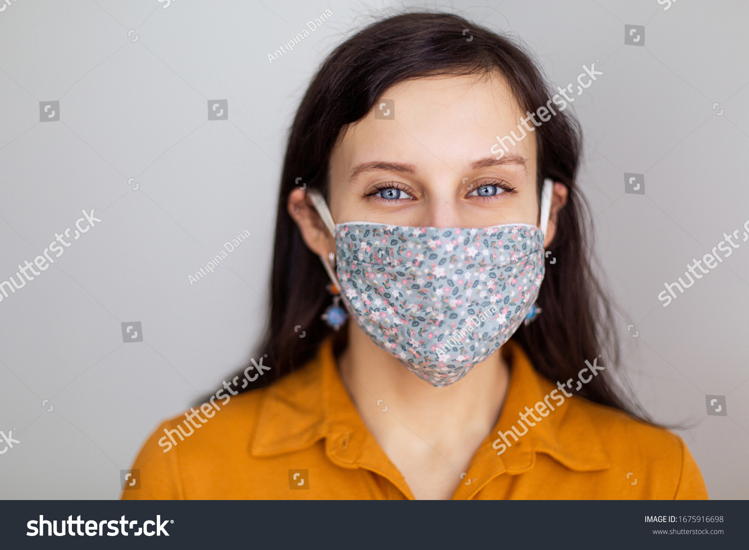 beautiful European girl with blue eyes in a handmade mask from the coronavirus. Design work protecting the security of disinfection of quarantine. Lack face cover. Pandemic houses white background #1675916698