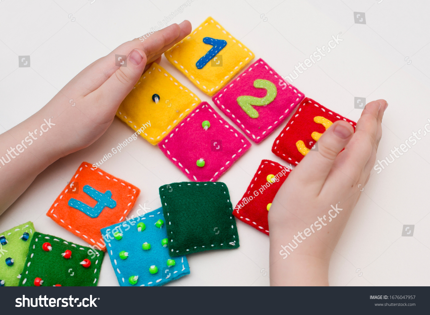 Home made game: find the right pair. Different color stuffed felt square with numbers and matching domino style dots. Early education, learning numbers. #1676047957