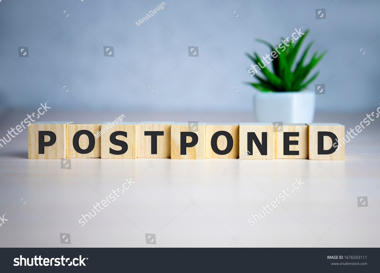 Postponed - words from wooden blocks with letters, postponed concept, top view background #1676593111