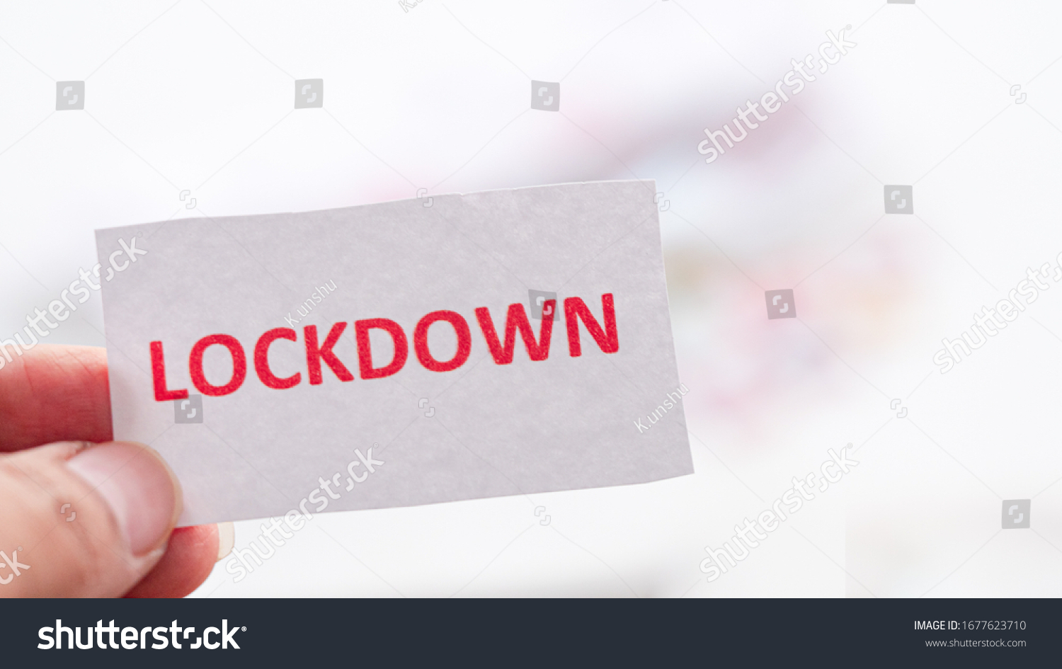 Hand holding note paper  have text  "Lockdown" blurred white background  Concept Lockdown covid-19. #1677623710