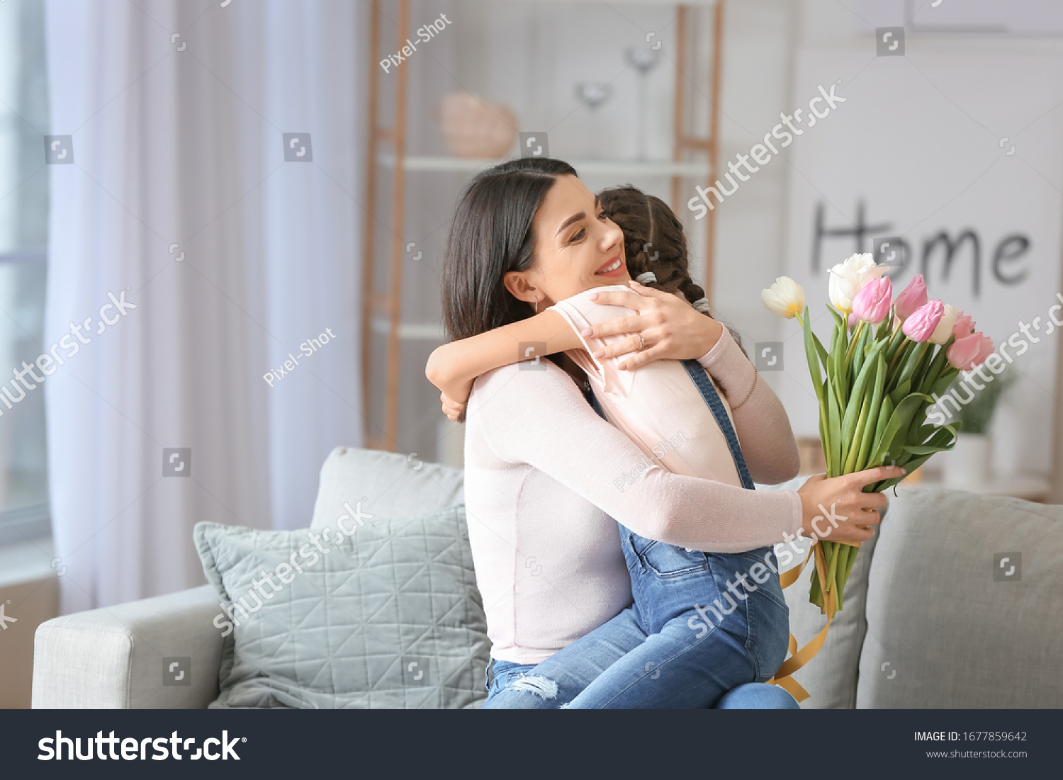 Little girl greeting her mom with Mother's Day at home #1677859642