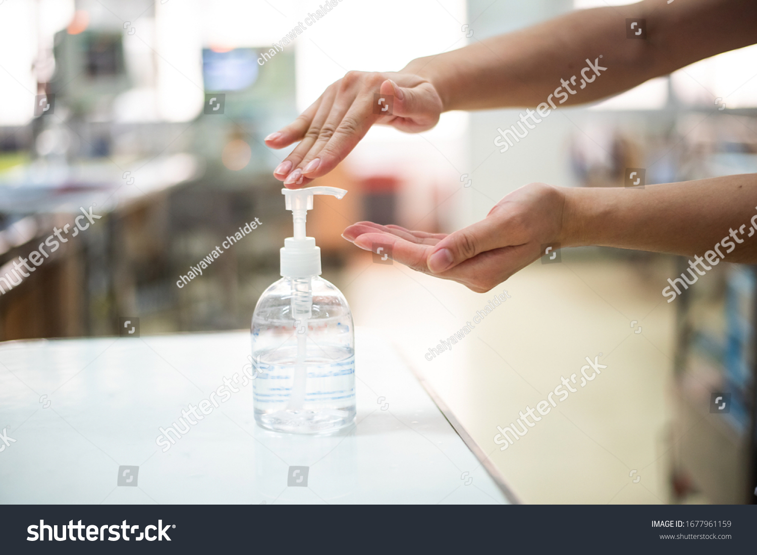 Nurse hands using wash hand sanitizer gel pump dispenser before 
nursing care a patient in hospital ward,Disinfection concept. #1677961159