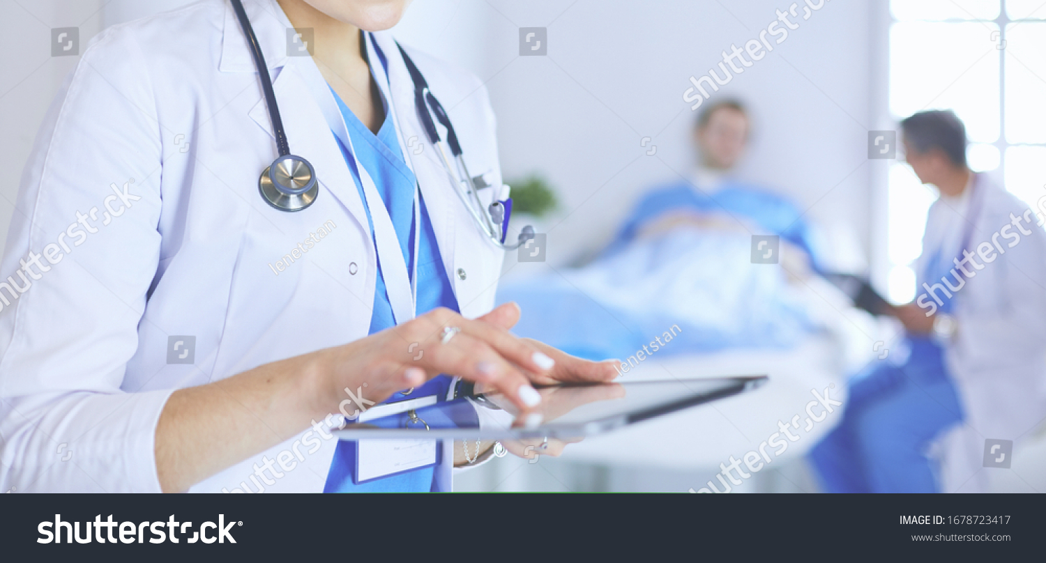 Female doctor using tablet computer in hospital lobby #1678723417