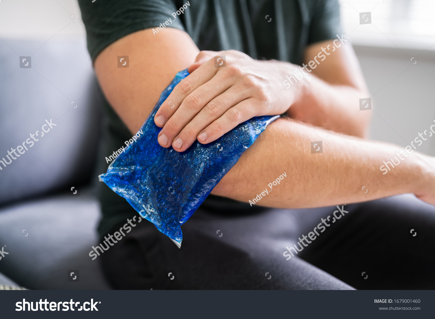 Man Using Ice Gel Pack On Injured Arm #1679001460