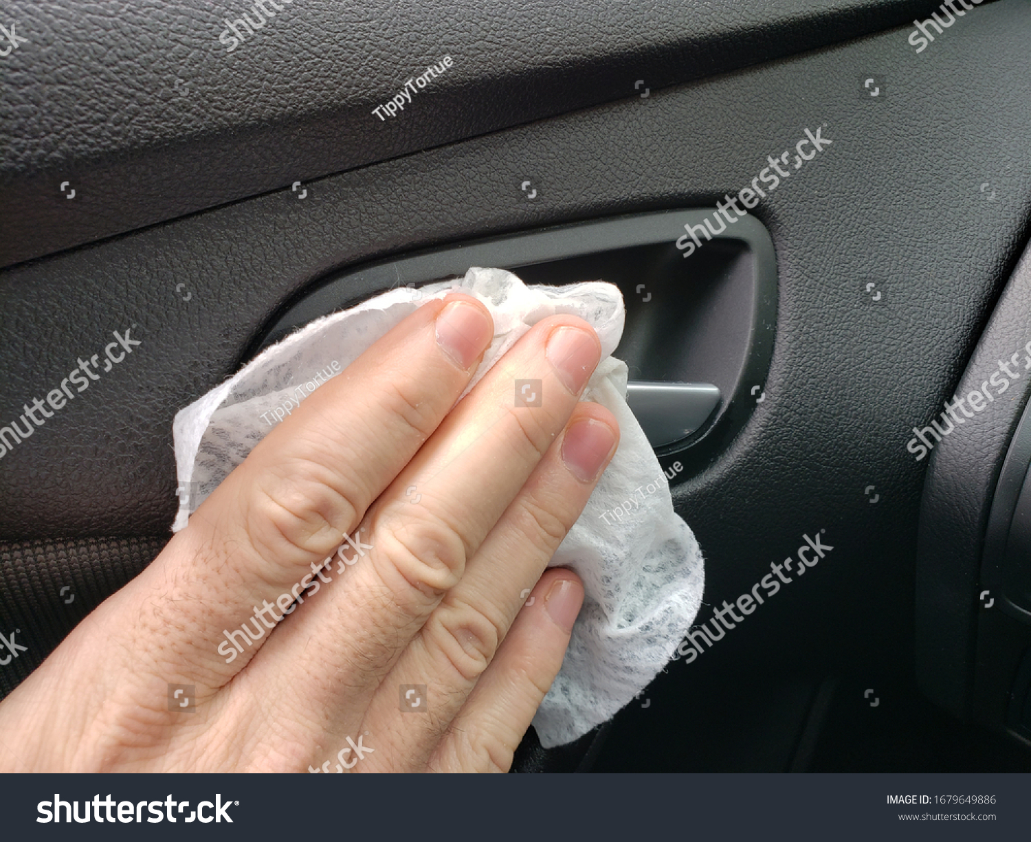 A man is using 99.9 disinfectant wipes to clean the interior parts of his vehicle during the coronavirus outbreak pandemic.