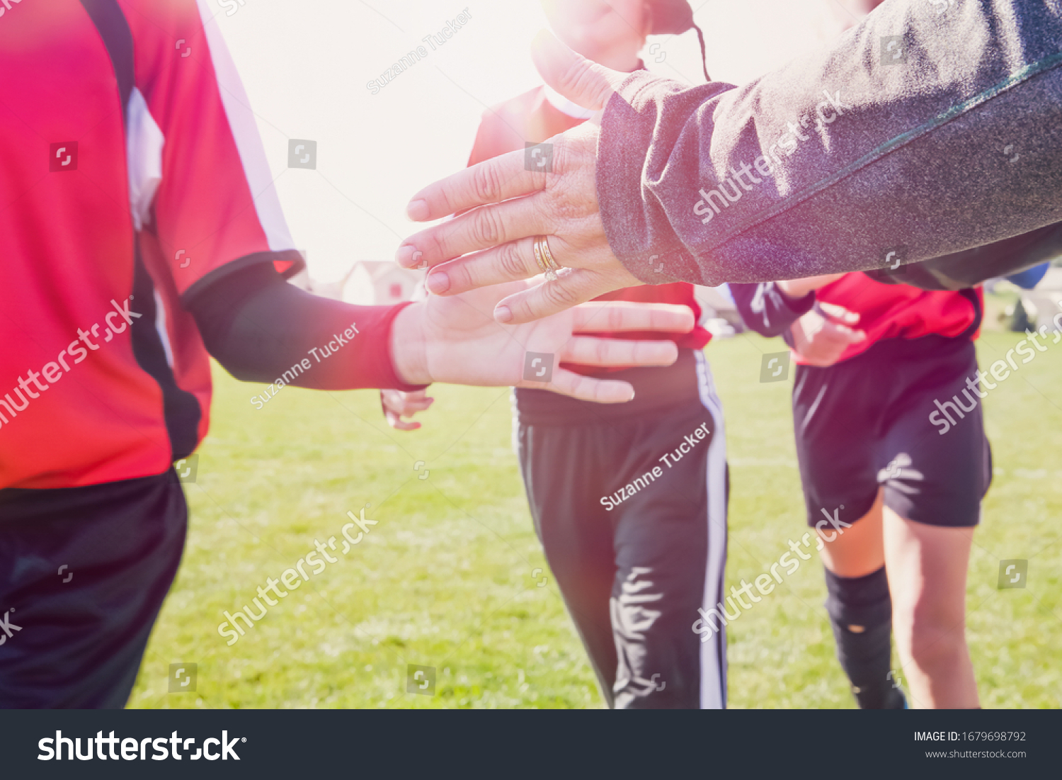 High Five line after a childs soccer game toned image, focus on adult hand #1679698792