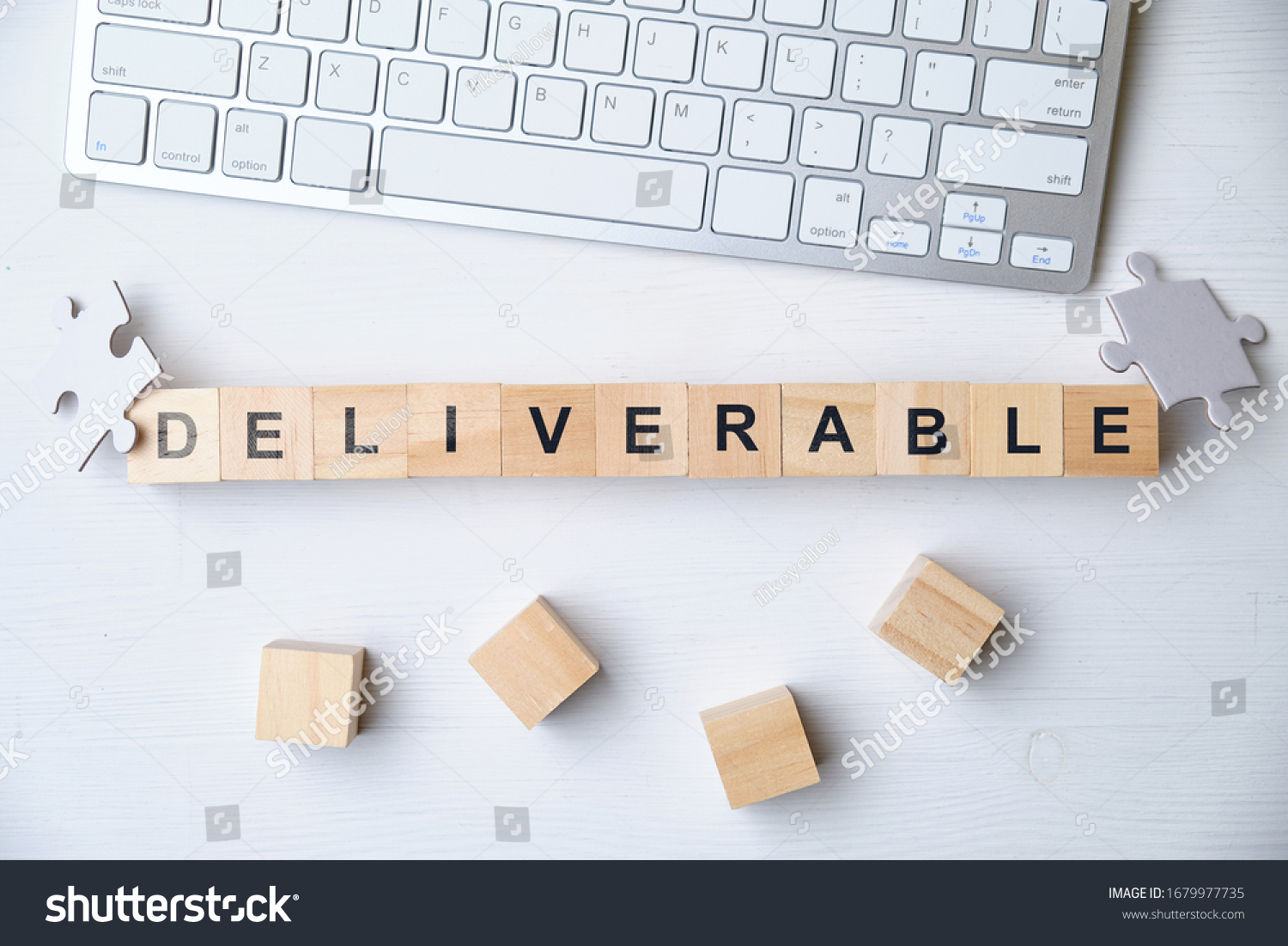 Modern business buzzword - deliverable. Top view on keyboard and puzzle with wooden blocks. Close up. Top view. #1679977735