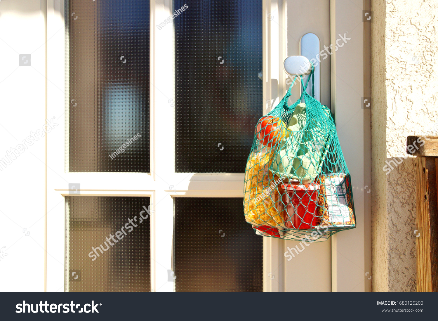 delivery during the quarantine. Shopping bag with Merchandise, goods and food is hanging at the front door, neighborhood Assistance concept at quarantine time because of coronavirus infection Covid-19 #1680125200