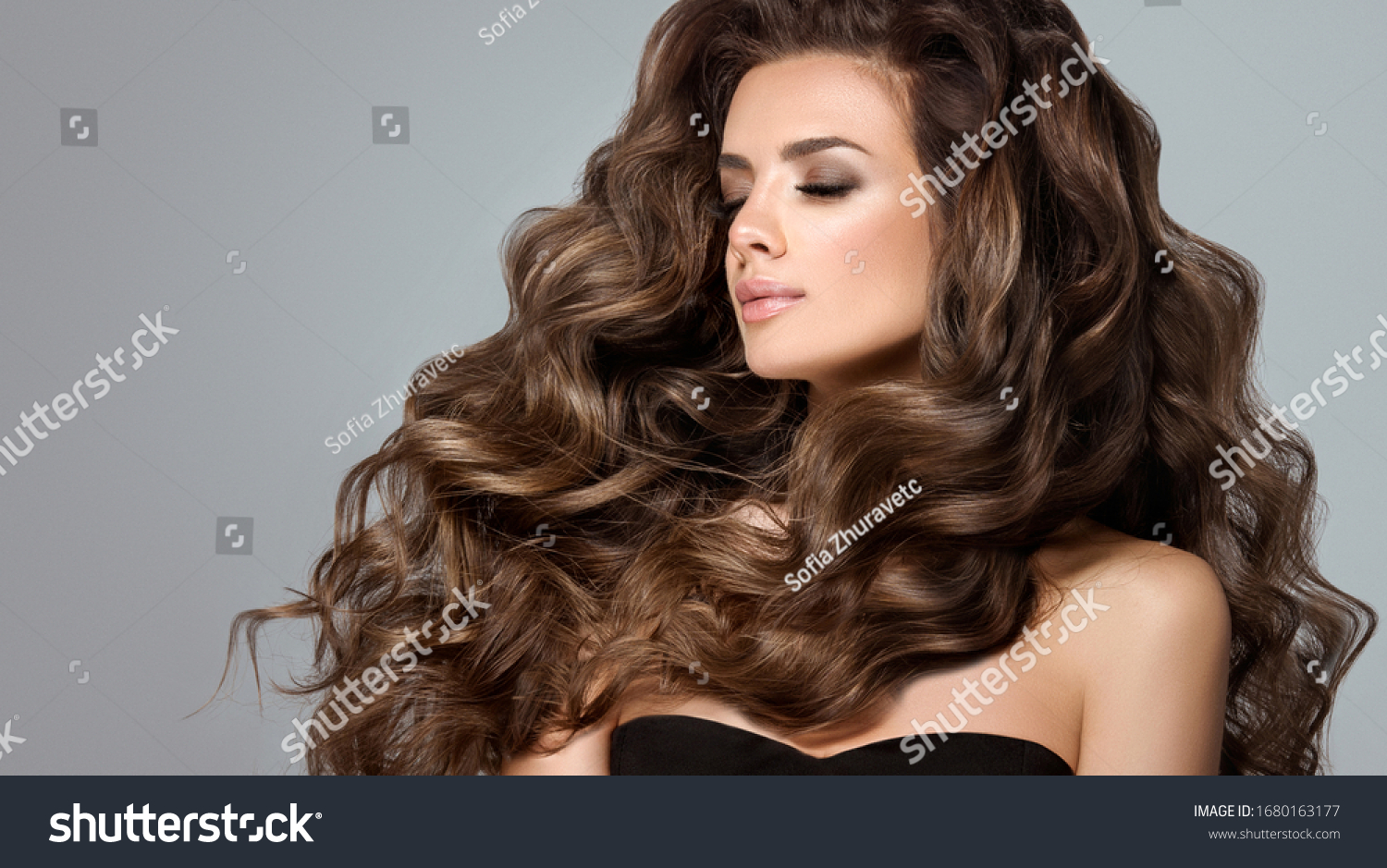 Beautiful model girl with long wavy and shiny hair . Brunette woman with curly hairstyle #1680163177