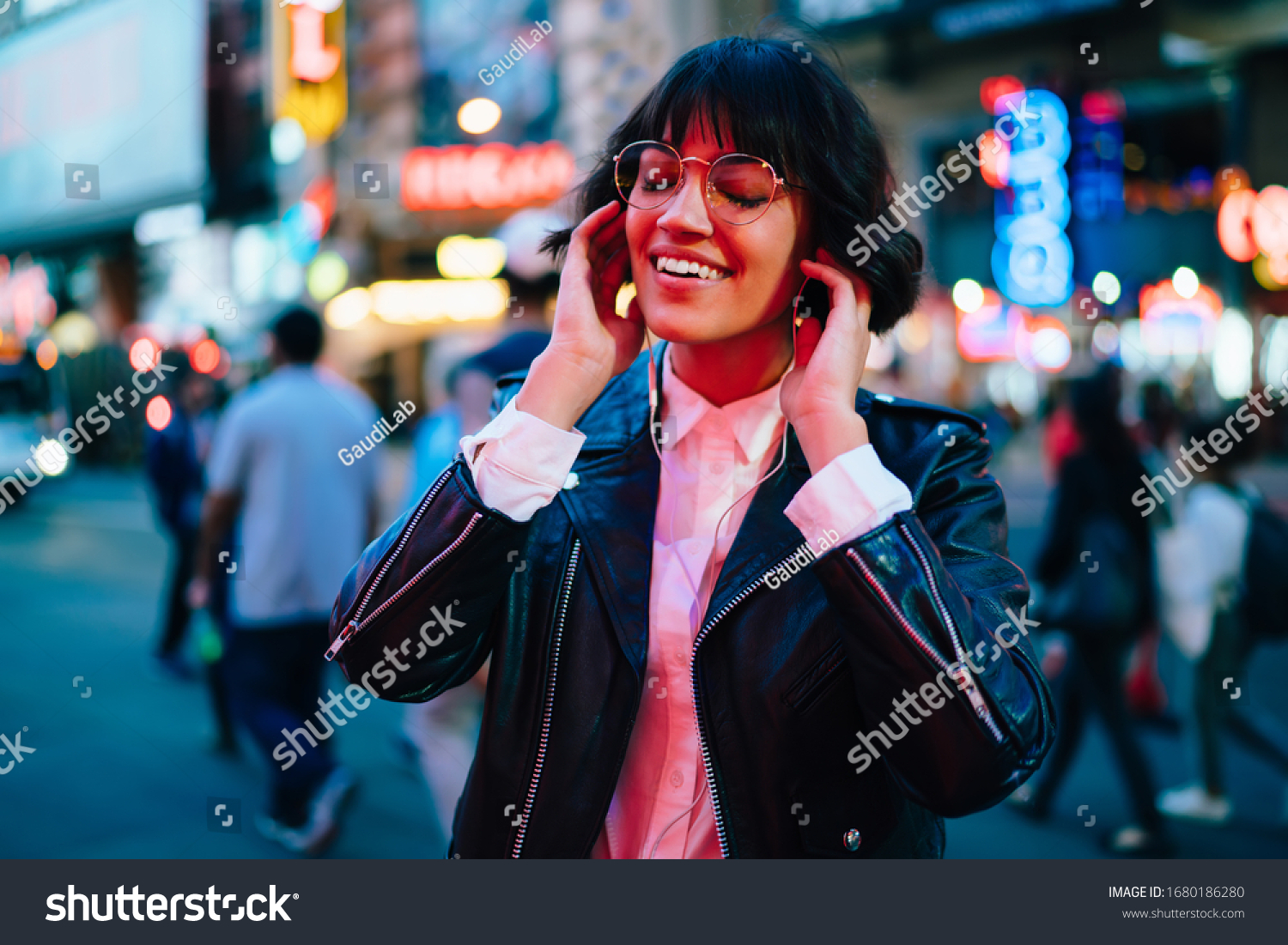 Cheerful woman teenager walking around evening megalopolis and relaxing with positive music, youthful hipster girl in electronic headphones listening audio playlist during leisure in New York #1680186280