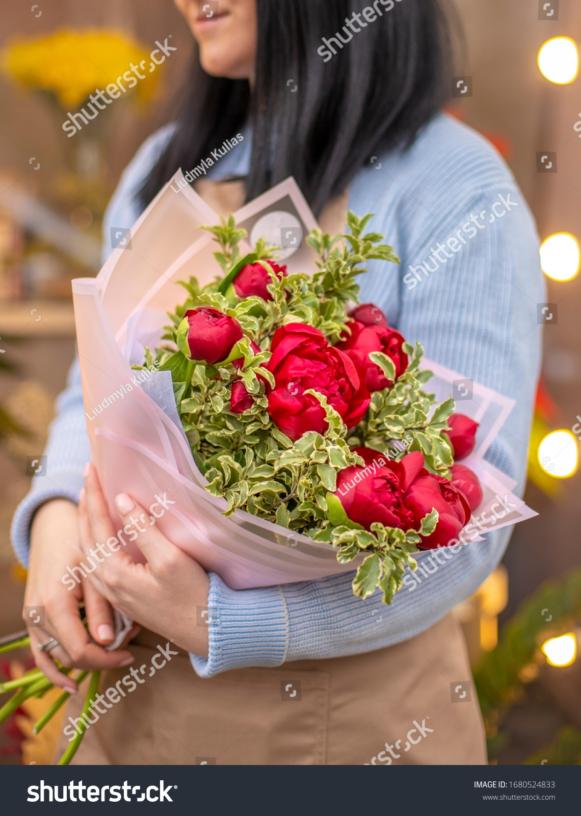 A bouquet of red peonies in florists hands. Fresh beautiful bouquet. #1680524833