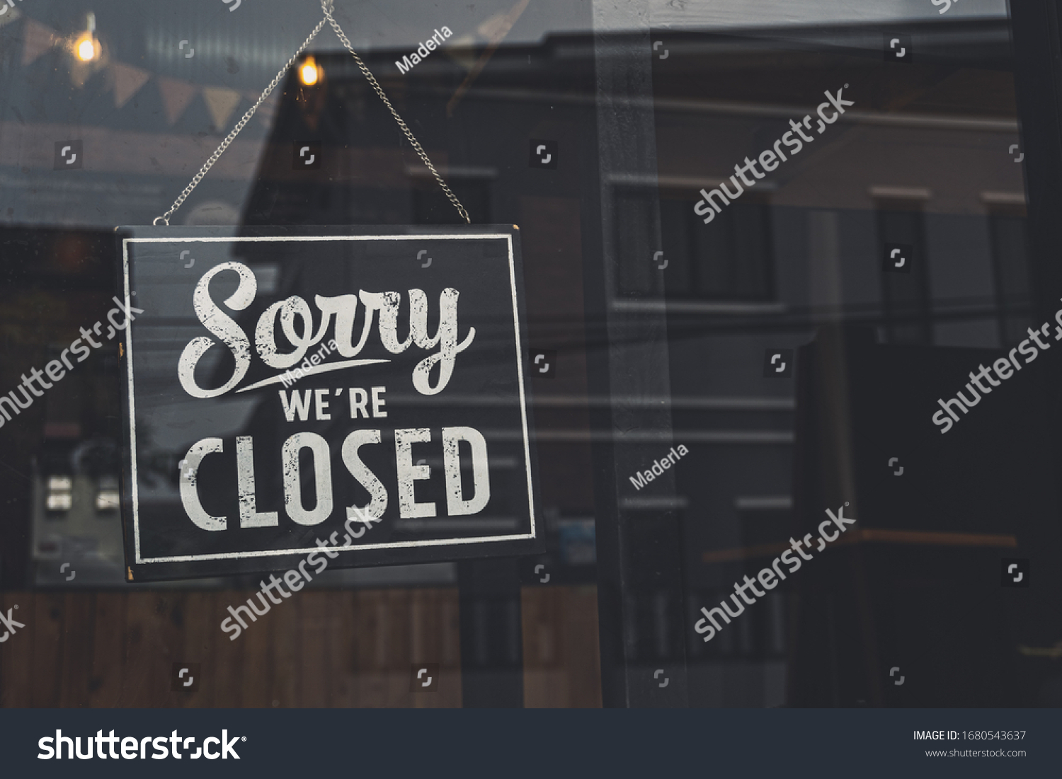 Vintage sorry we are closed sign hanging on a glass door. #1680543637