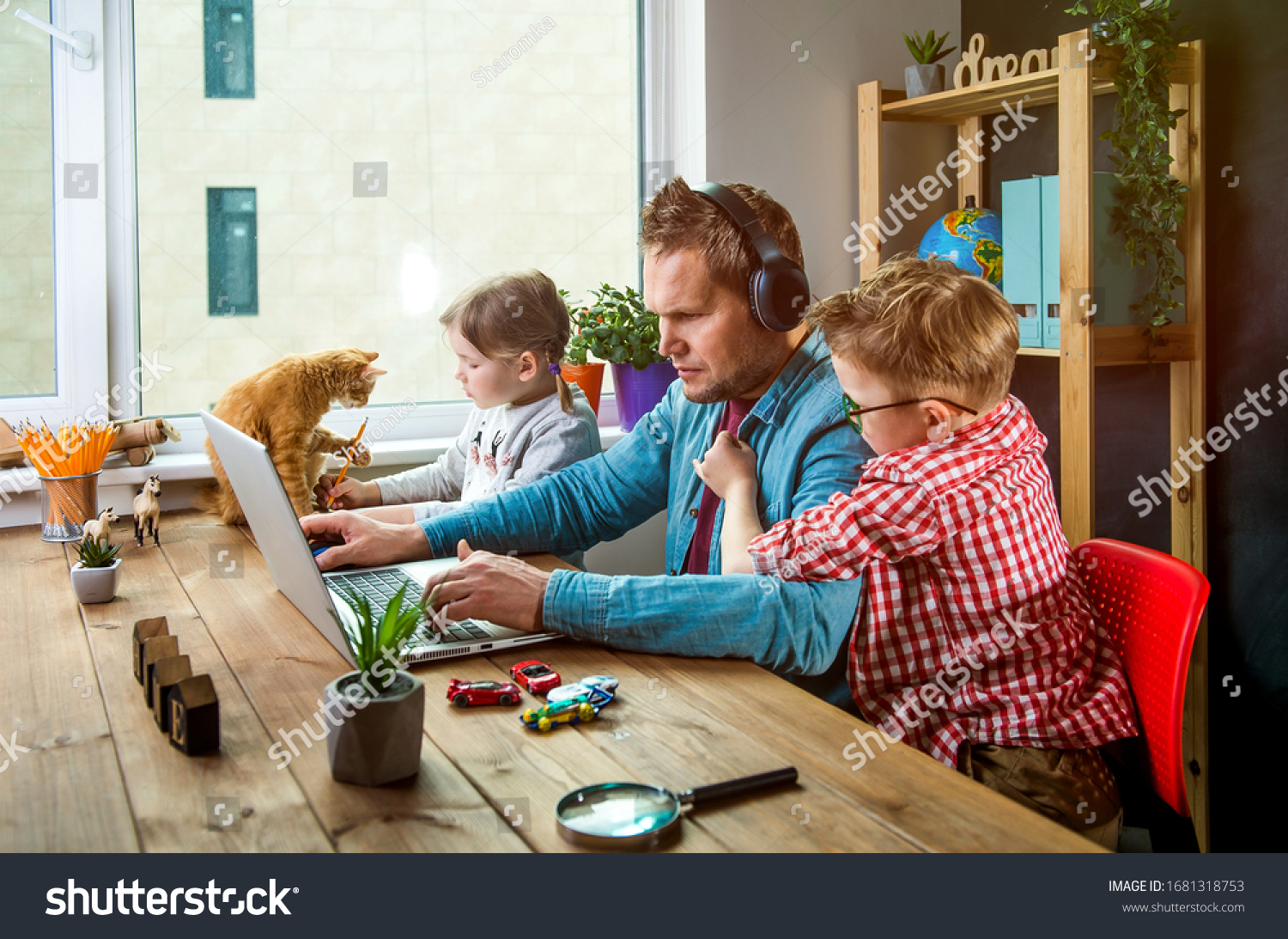 Work from home. Man works on laptop with children playing around. Family together with pet cat on table #1681318753