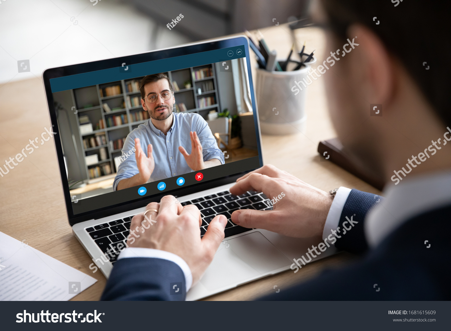 Back view of businessman talk with male business partner using video call on laptop discuss work project online, male client talk with colleague or coworker, speak on webcam conference on computer #1681615609