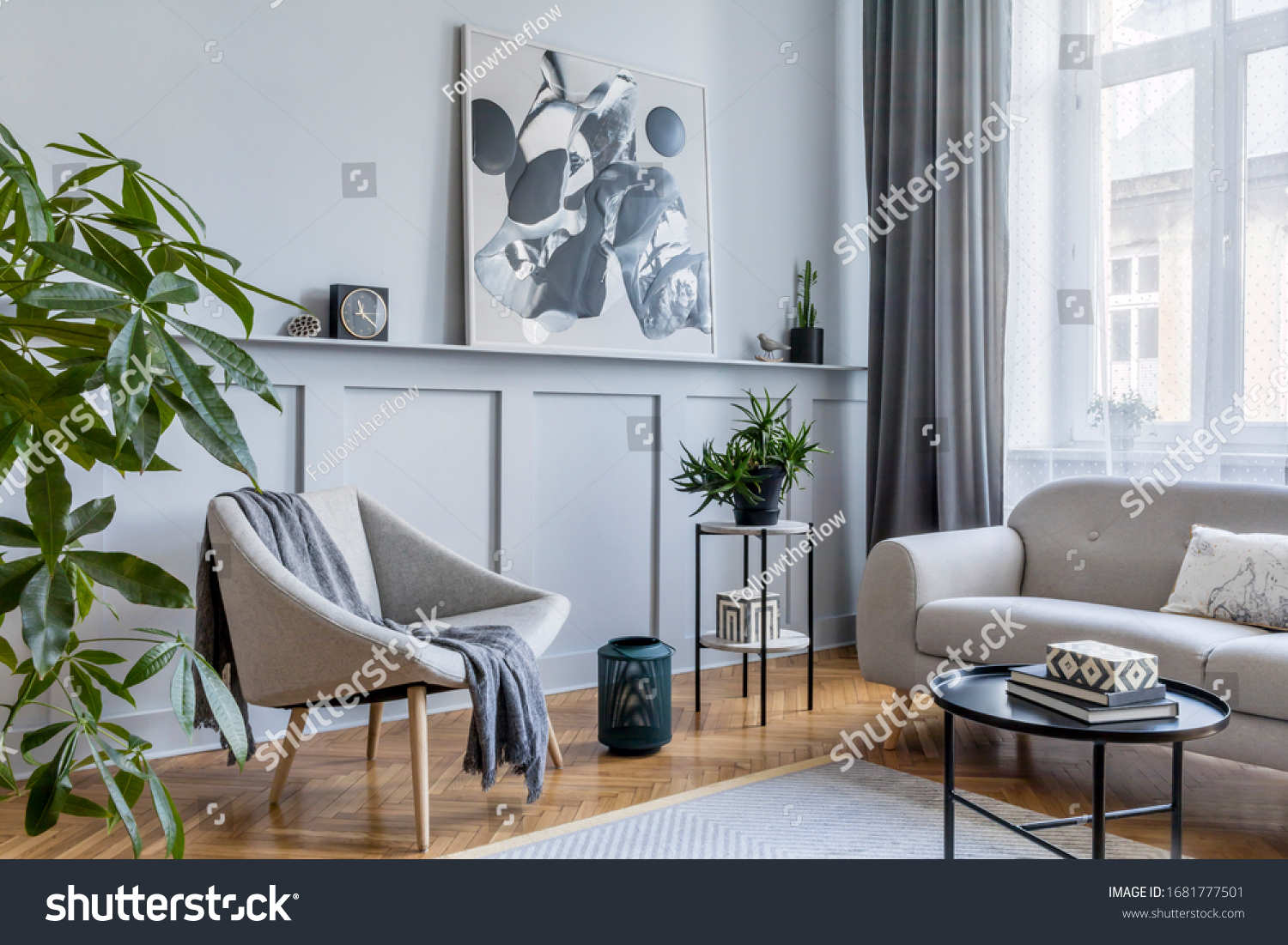 Stylish scandinavian home interior of living room with design gray sofa, armchair, marble stool, black coffee table, modern paintings, decoration, plant and elegant personal accessories in home decor. #1681777501
