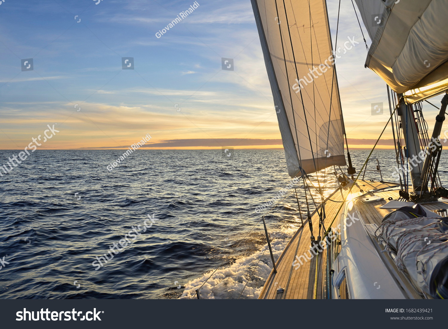 Sailboat sailing in the Mediterranean Sea at sunset #1682439421