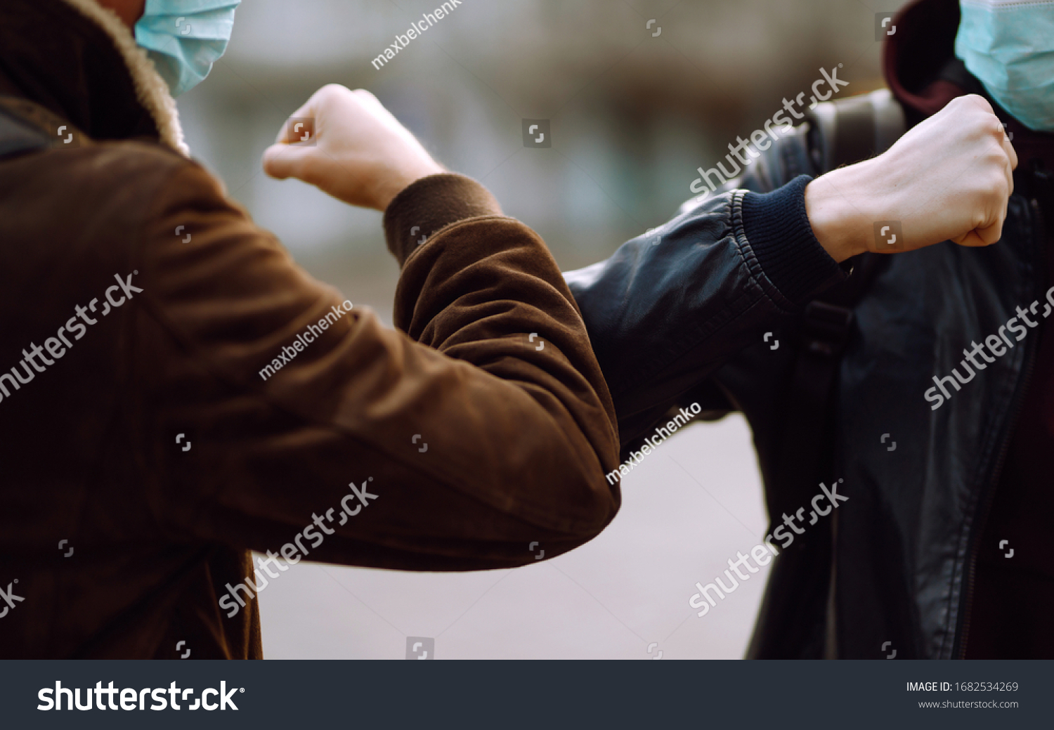 Friends in protective medical mask on his face greet their elbows in a quarantine city. Elbow bump is new greeting to avoid the spread of coronavirus. Don't shake hands. Stop handshakes. #1682534269