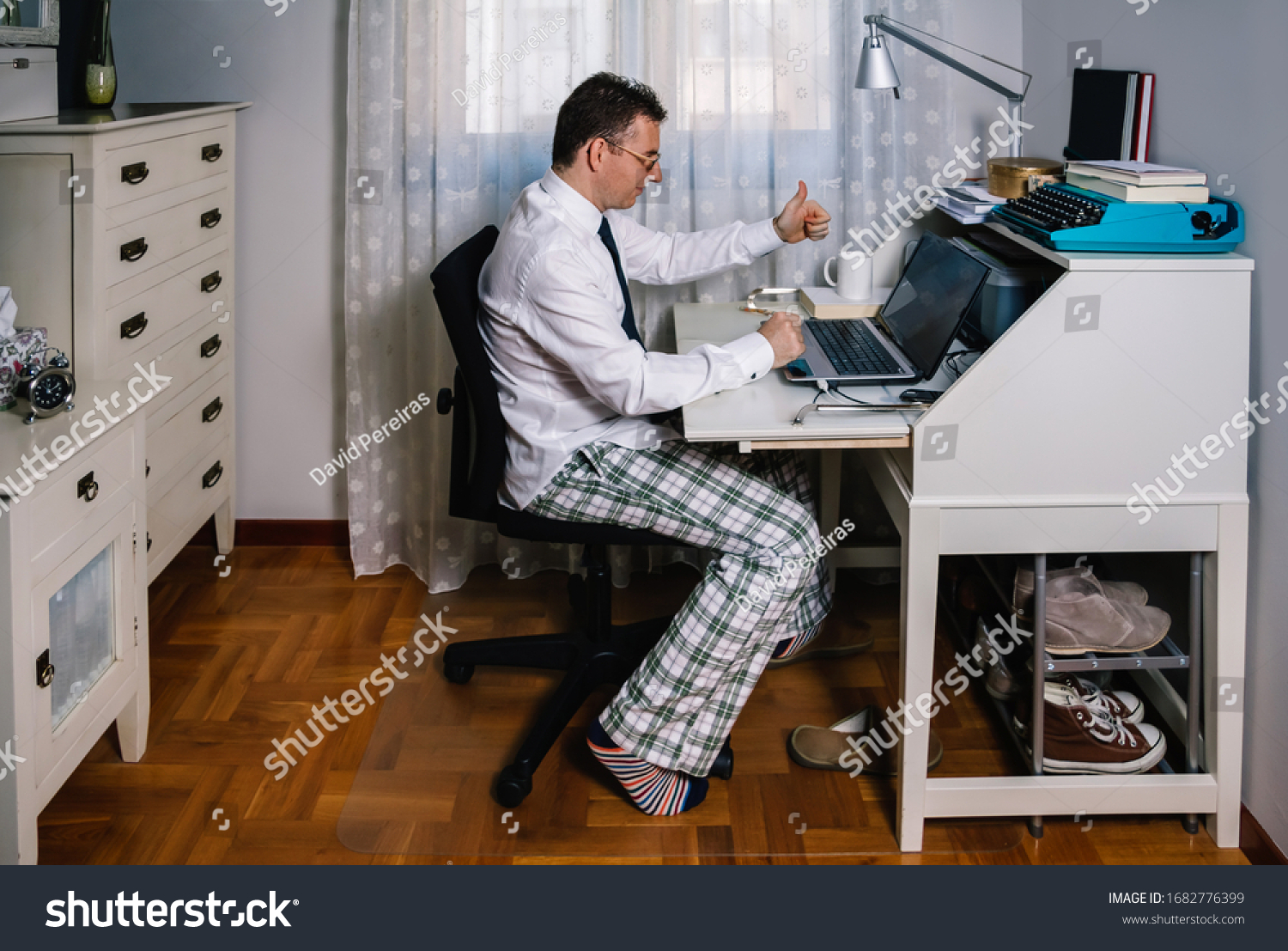 Man working from home with laptop wearing shirt, tie and pajama pants #1682776399