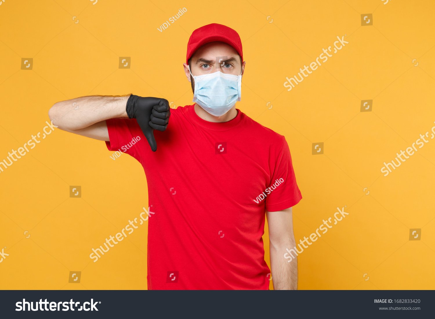 Delivery man in red cap blank t-shirt uniform sterile face mask gloves isolated on yellow background studio Guy employee working courier Service quarantine pandemic coronavirus virus concept #1682833420