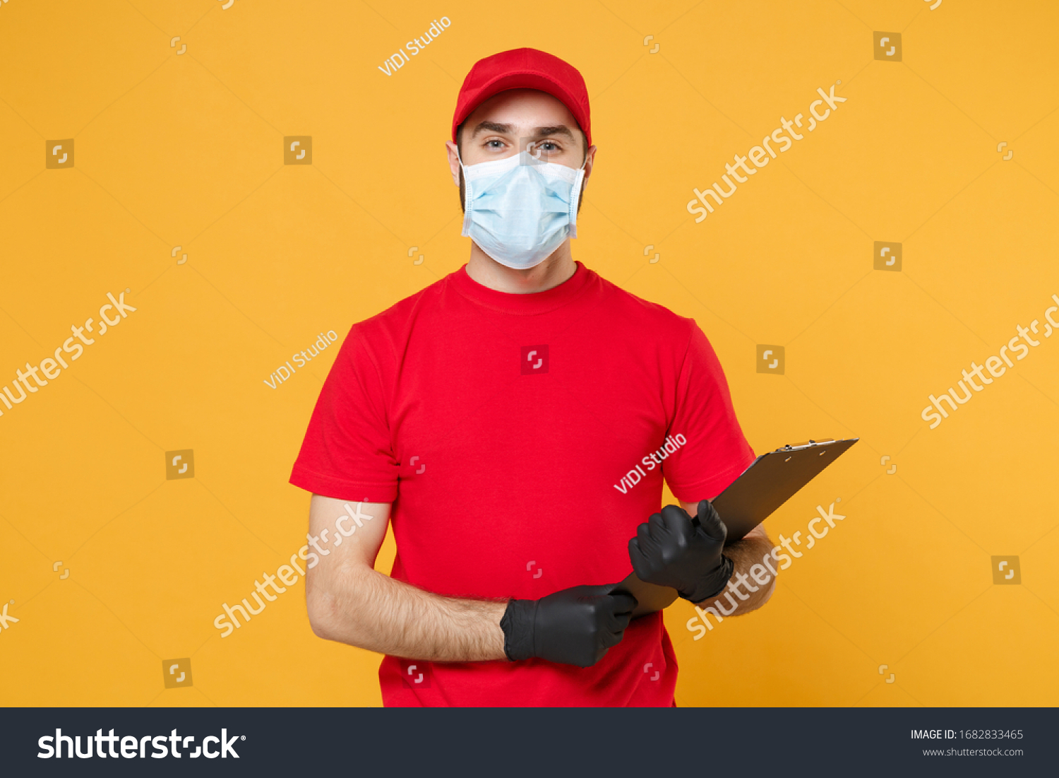 Delivery man in red cap blank t-shirt uniform sterile face mask gloves isolated on yellow background studio Guy employee working courier Service quarantine pandemic coronavirus virus concept #1682833465