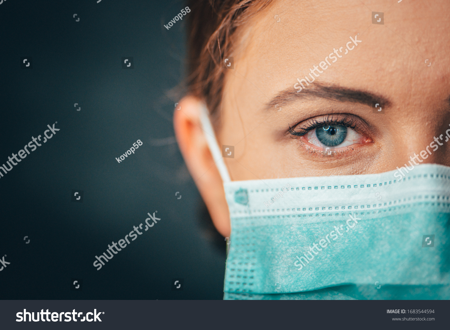 Close up portrait photo, Eye of Yong Female Doctor. Protection against contagious disease, coronavirus, hygienic face surgical medical mask to prevent infection. Black background #1683544594