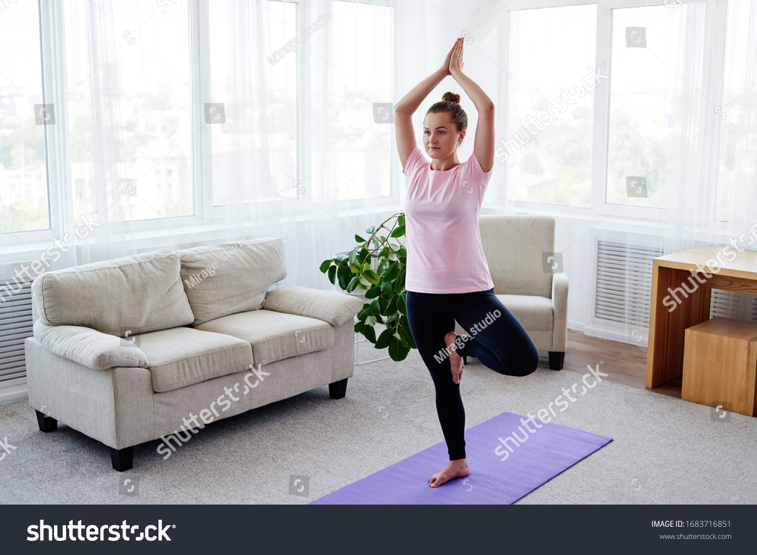 Portrait of young woman practicing balance yoga asana Vrikshasana at home indoor, copy space, back view. Girl doing tree pose, full length. Relaxing and doing yoga. Wellness and healthy lifestyle #1683716851