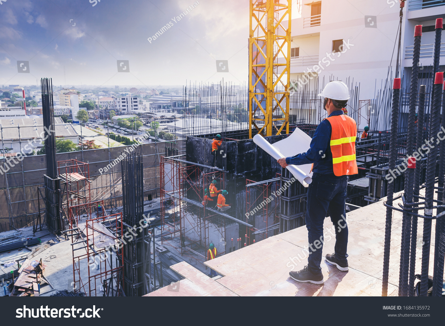 Smart civil architect engineer inspecting and working outdoors building side with blueprints. engineering and architecture concept. #1684135972