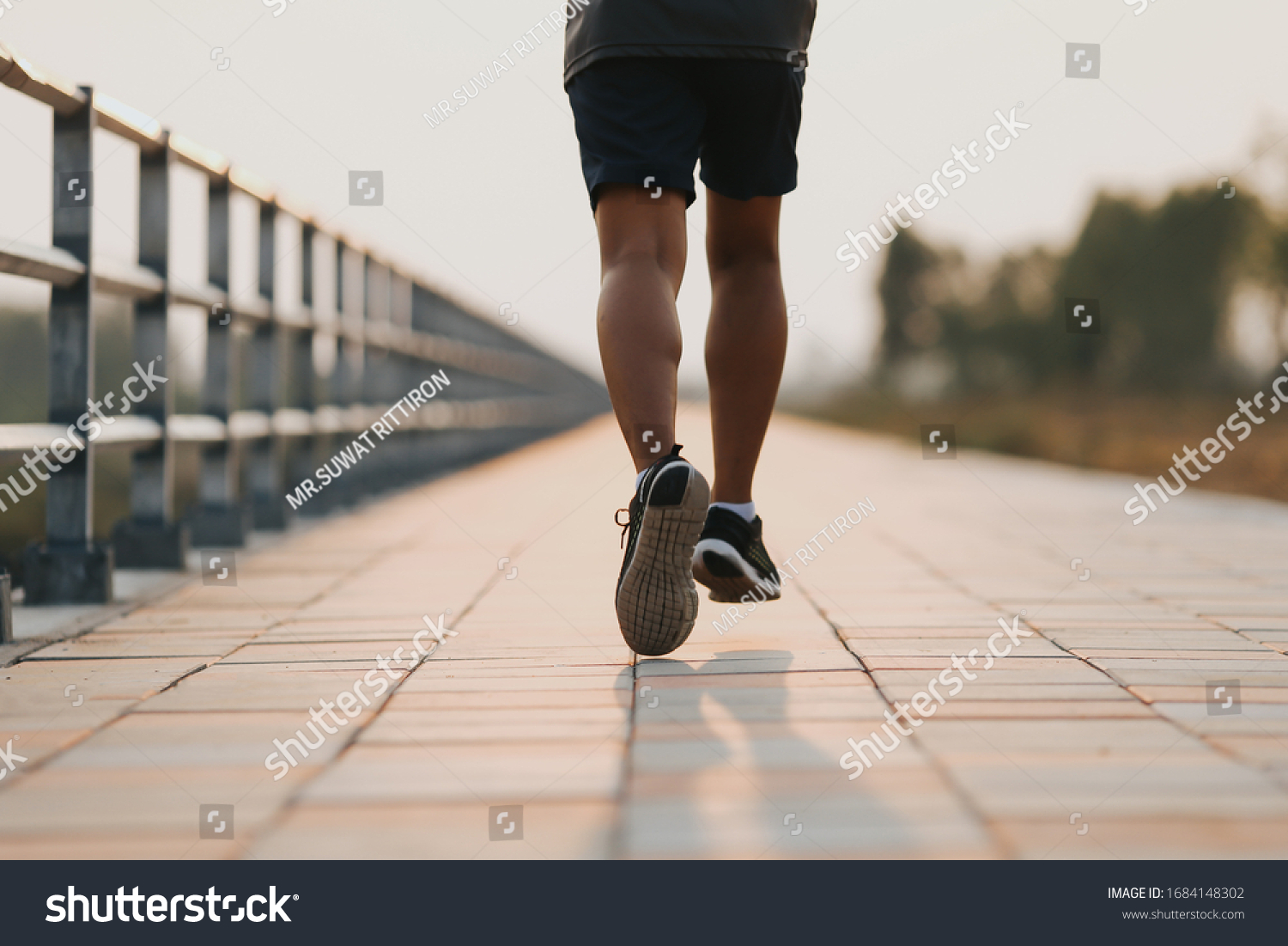 Runner feet running on road closeup on shoe. MAN fitness sunrise jog workout welness concept. #1684148302