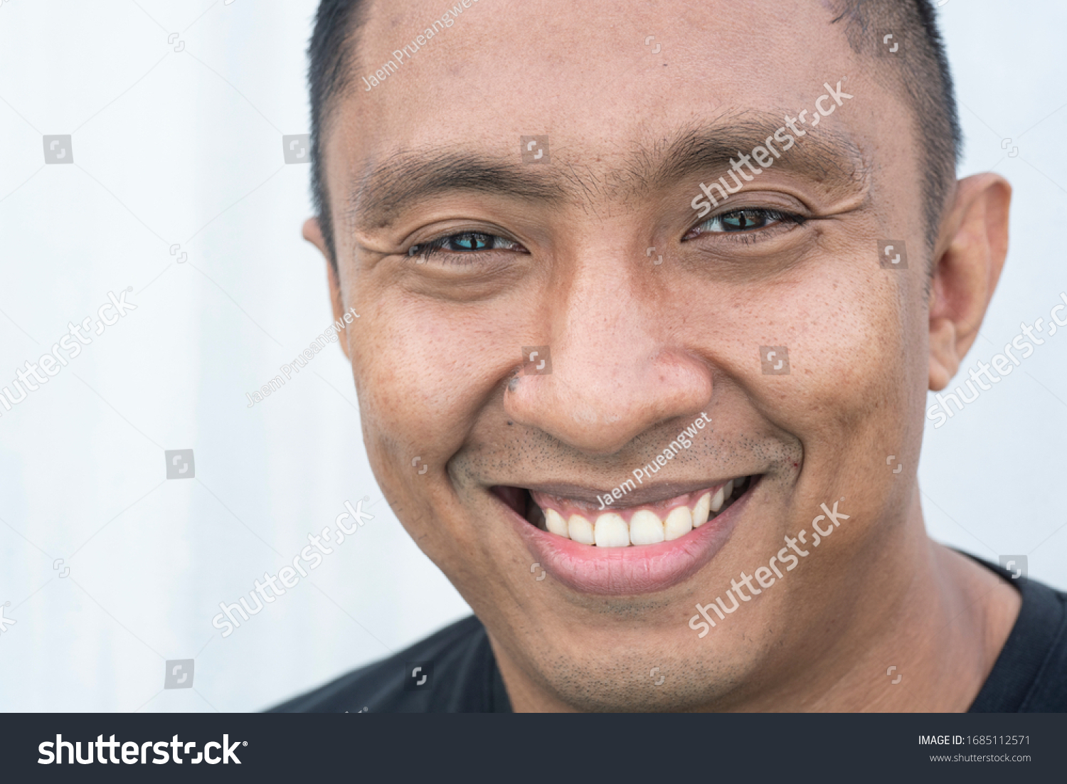 A closeup portrait of a face of an Asian Indonesian male model who smiles with his mouth wide open. he looks happy. Picture is on white background #1685112571