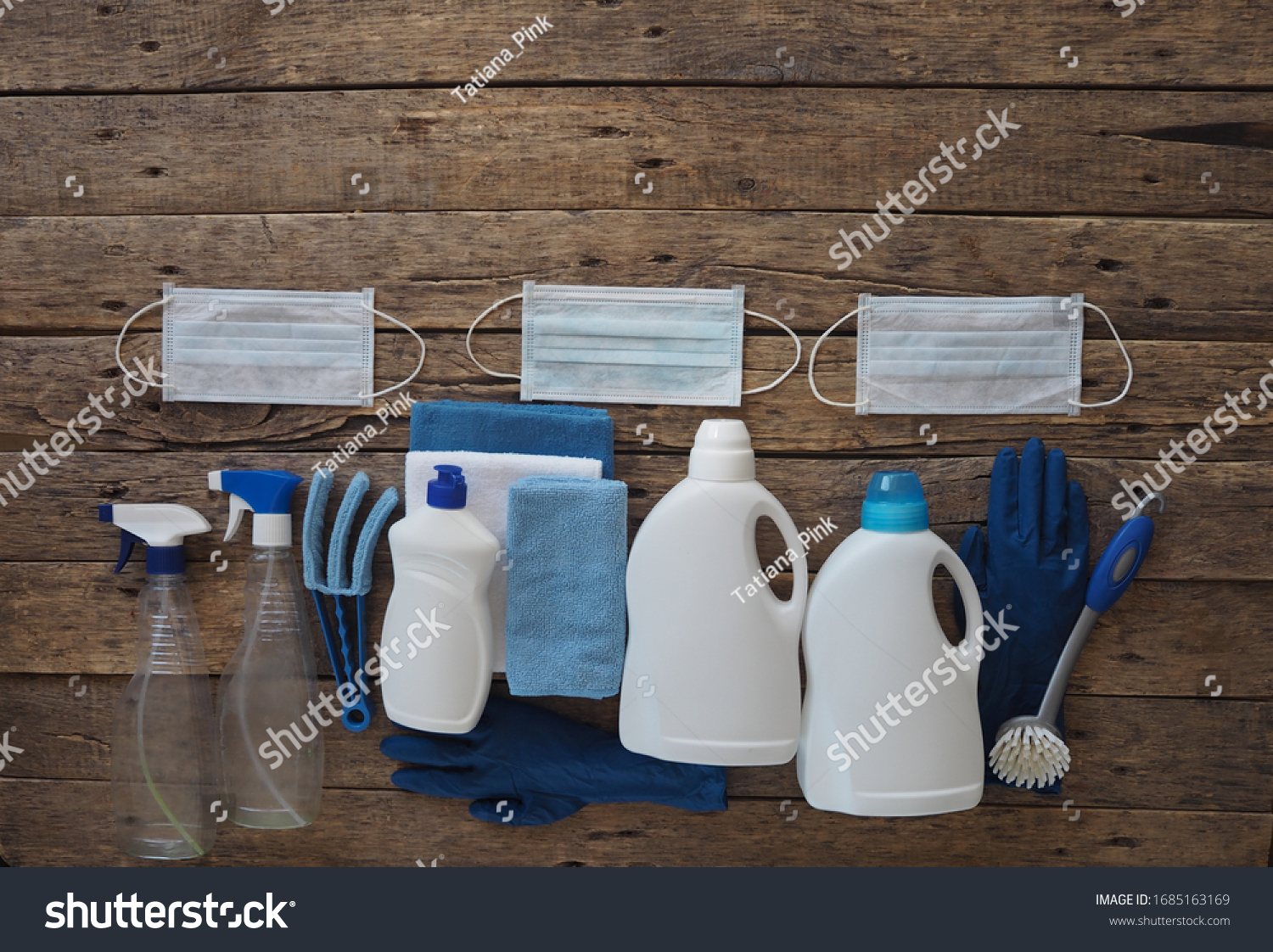 Koronavirus. The idea of cleaning the house during quarantine. Medical protective masks and plastic rubble with cleaning and disinfectants on a natural wooden background. Spend time at home.  #1685163169
