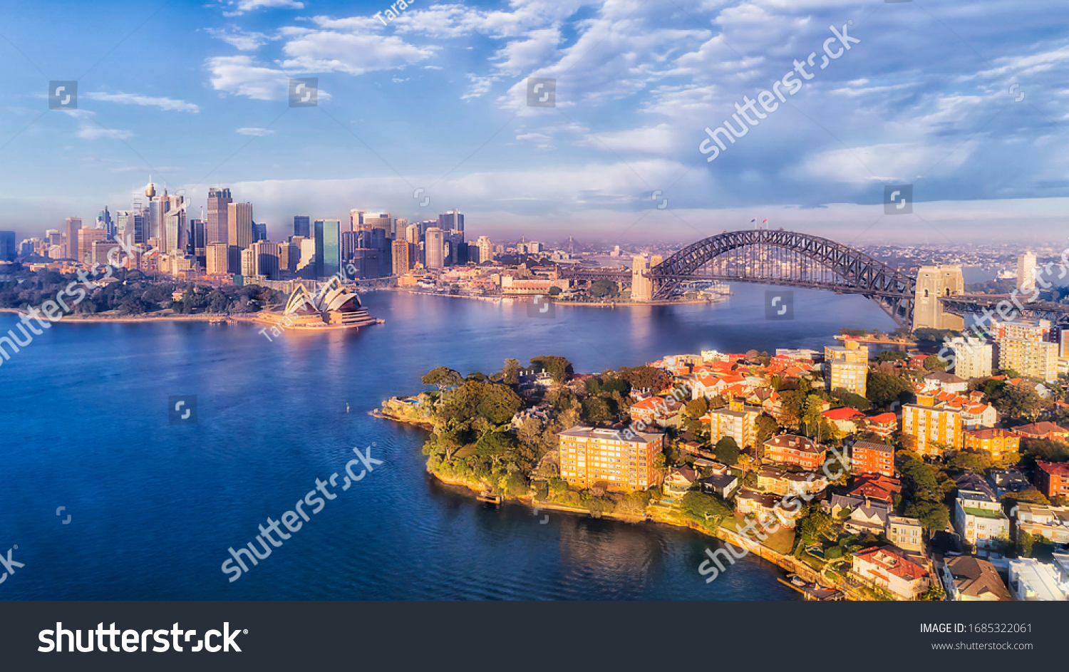 BLue water of Sydney harbour with major city landmarks on waterfront of CBD and north shore in aerial view.
