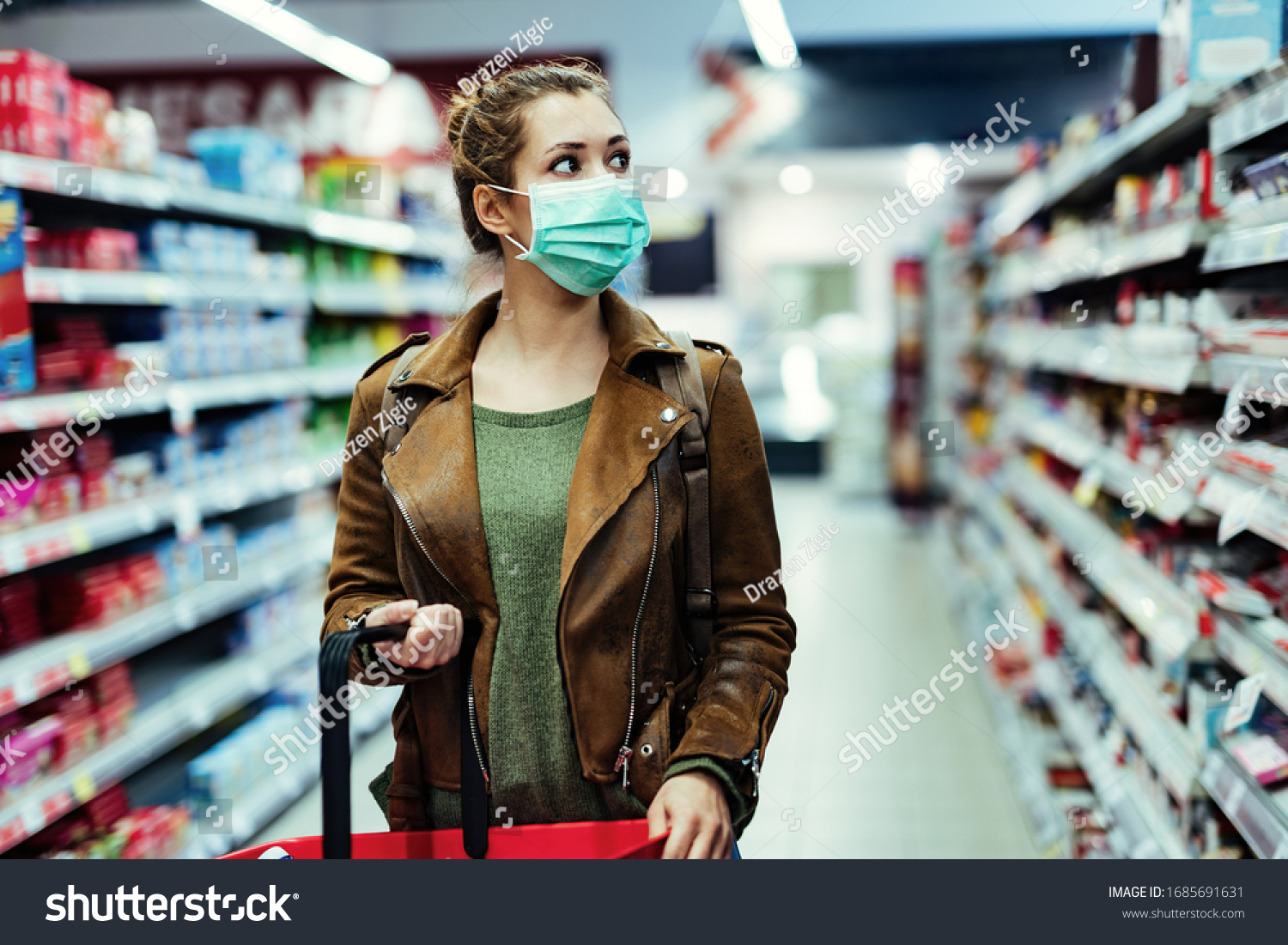 Young woman with face mask walking through grocery store during COVID-19 pandemic.  #1685691631