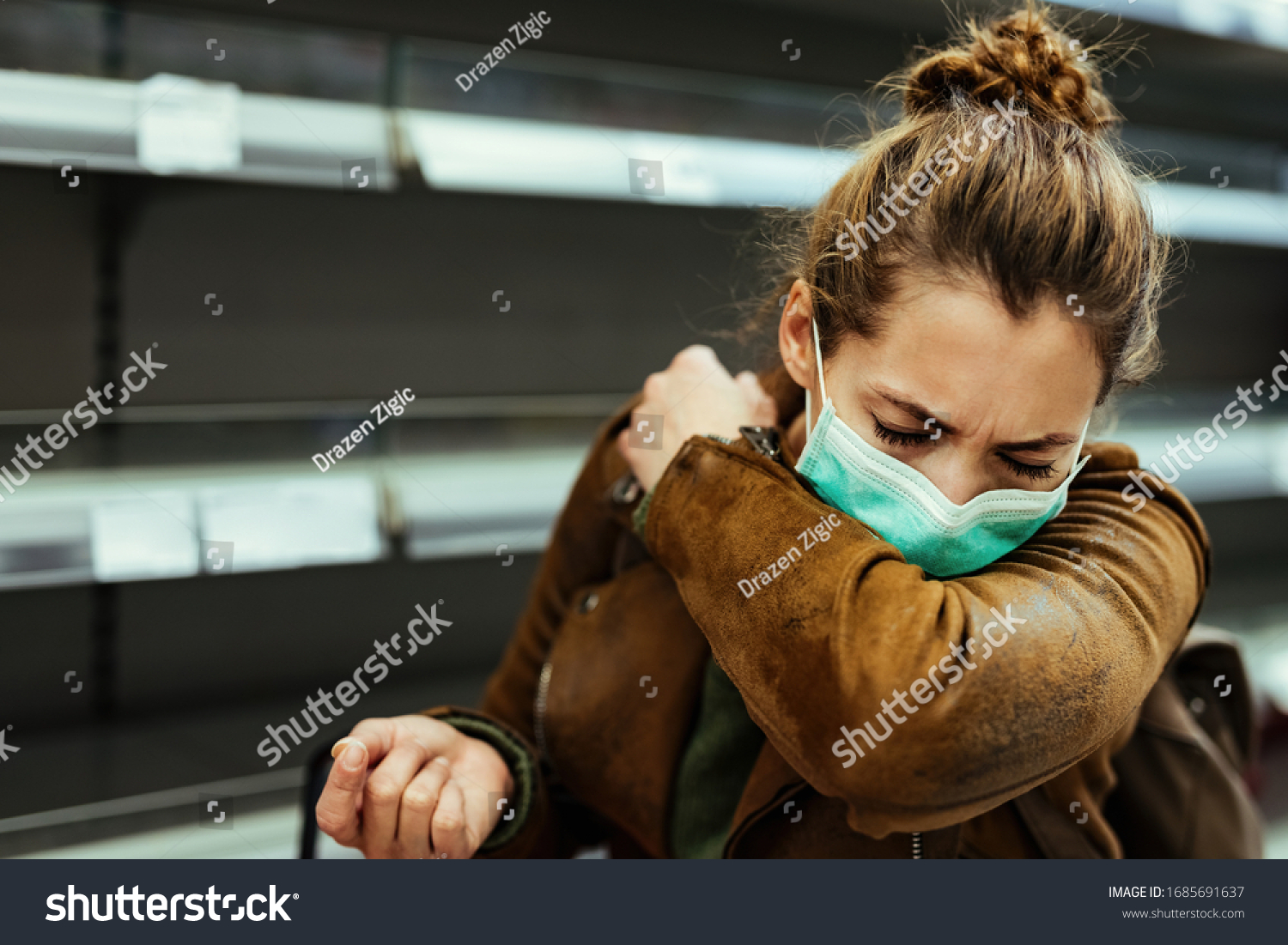 Sick woman buying in supermarket and coughing into elbow during COVID-19 pandemic.  #1685691637