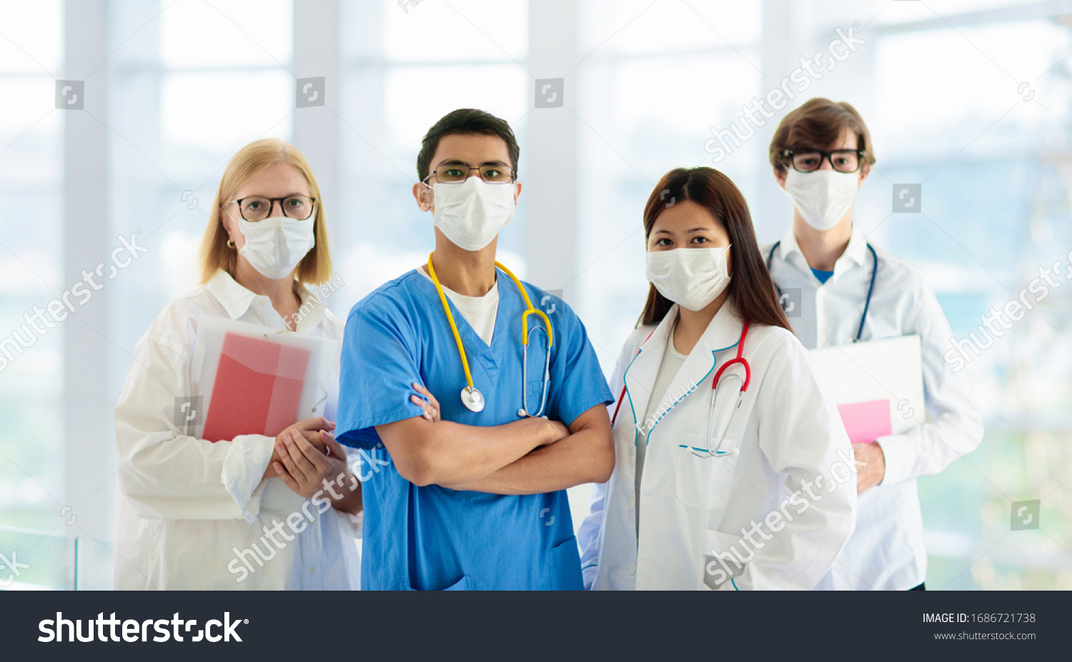 International doctor team. Hospital medical staff. Mixed race Asian and Caucasian doctor and nurse meeting. Clinic personnel wearing face mask and stethoscope. Coronavirus outbreak. #1686721738