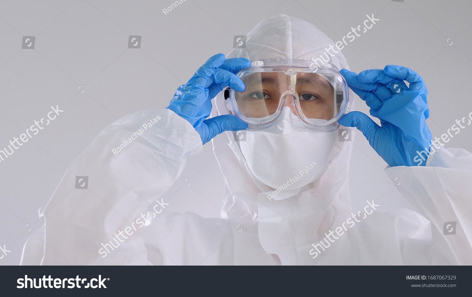Asian doctor in protective hazmat PPE suit wearing face mask and eyeglasses #1687067329