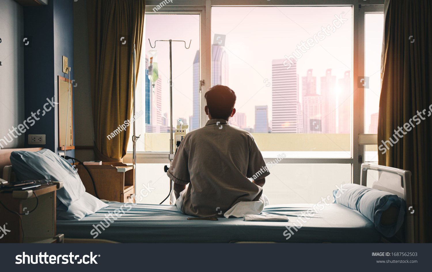 patient sat on the bed and looked out the window in the hospital alone and had stress, boredom, loneliness, anxiety. / Health care and medical #1687562503