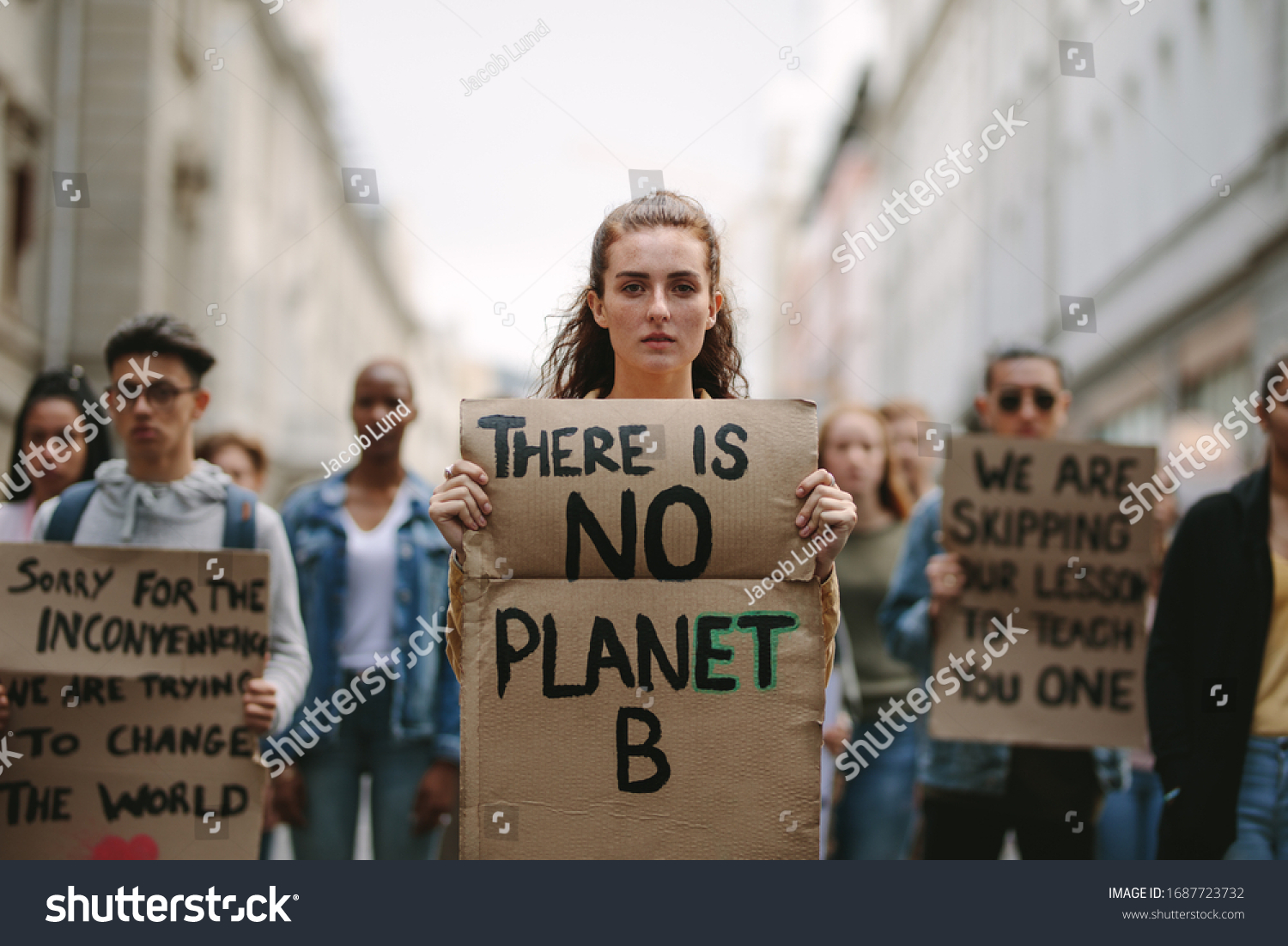Group of students on the streets demonstrating against climate change. People protesting for problem in ecology, environment, global warming, industrial influence, climate emergency. #1687723732