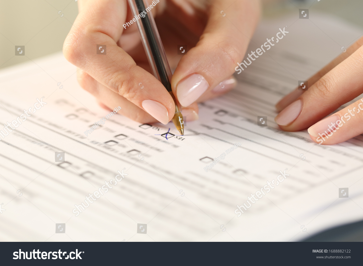 Close up of woman hands filling form crossing yes checkbox on a desk #1688882122