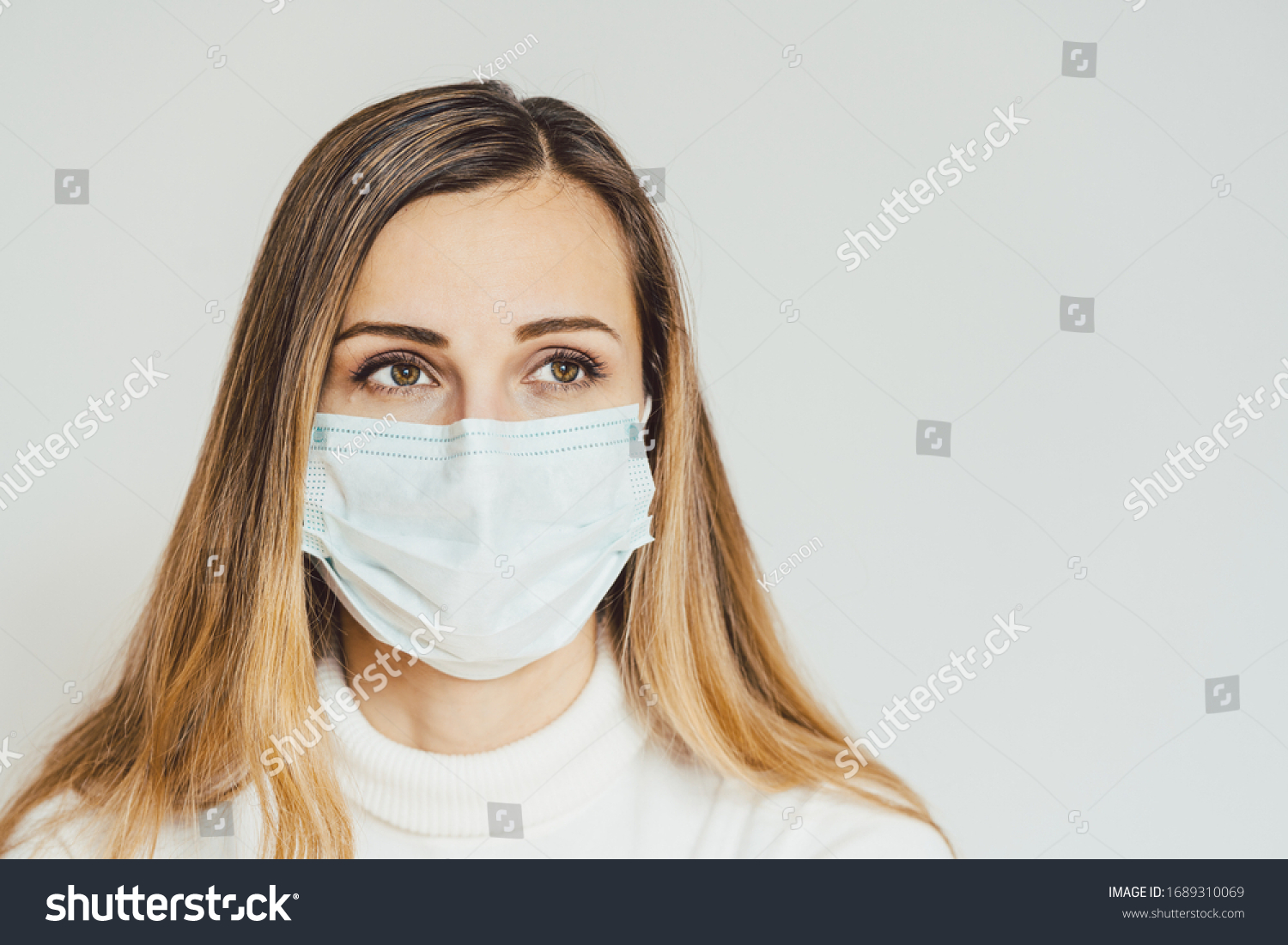Anxious woman with face mask worried about the Covid-19 outbreak staying at home #1689310069