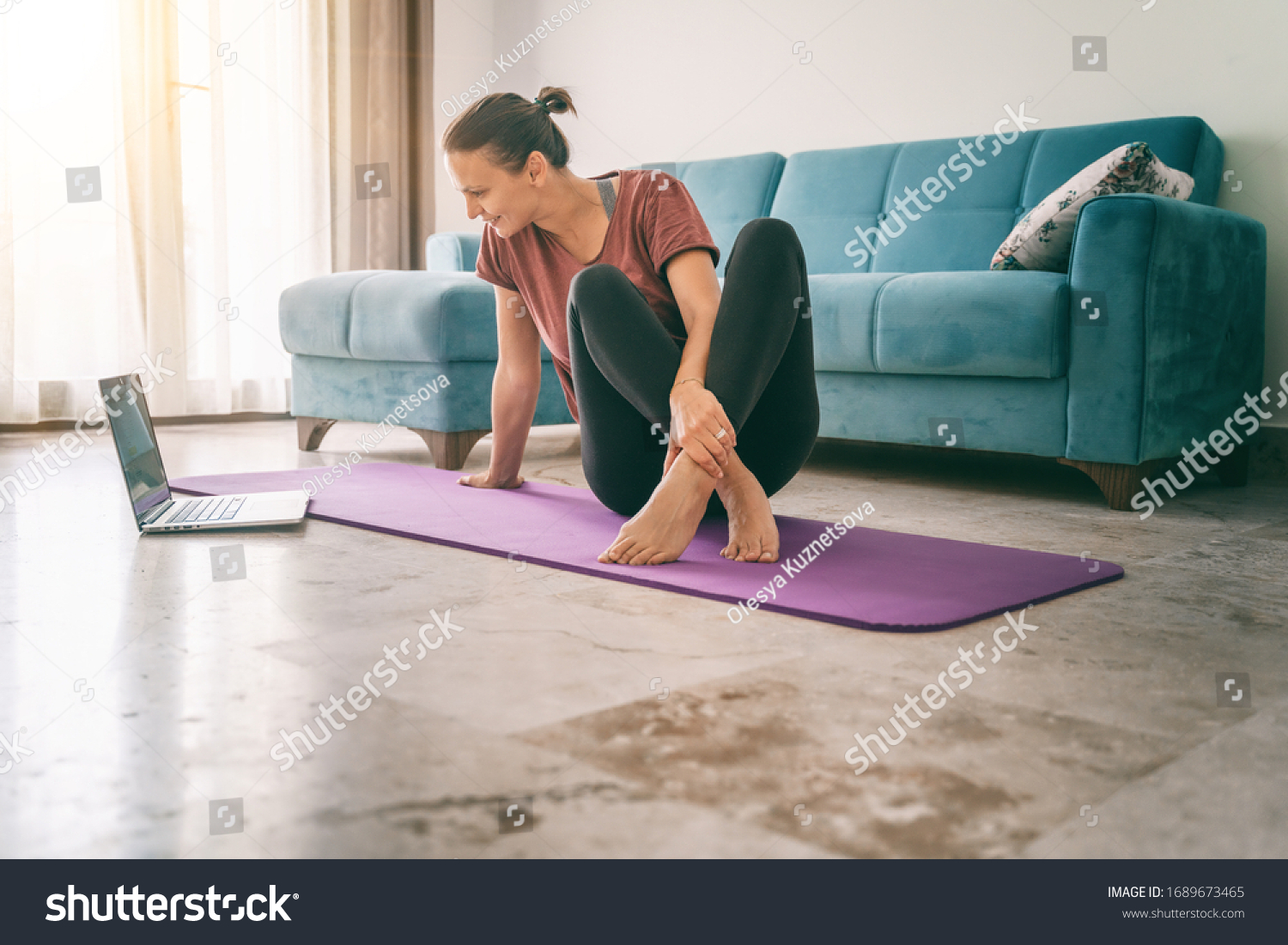 Attractive young woman doing yoga stretching yoga online at home. Self-isolation is beneficial, entertainment and education on the Internet. Healthy lifestyle concept. #1689673465