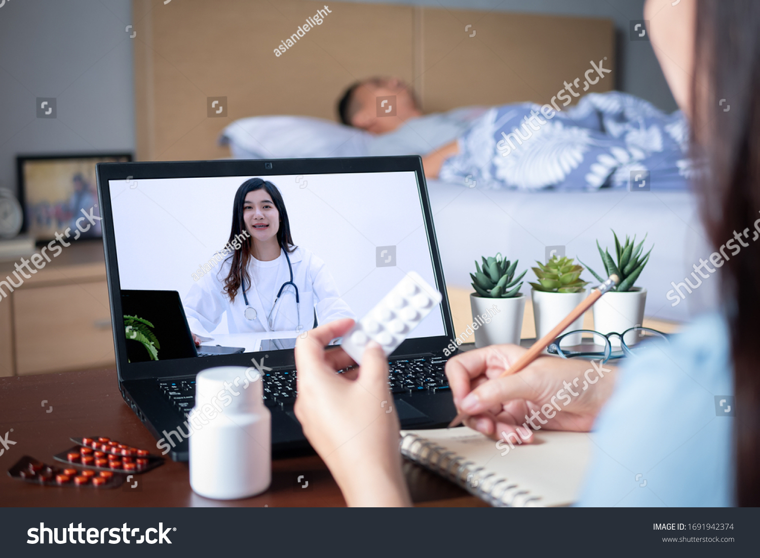 Patient's relatives use video conference, make online consultation with doctor on notebook computer, ask doctor about illness , medication via video call. Telehealth, Telemedicine and online hospital #1691942374