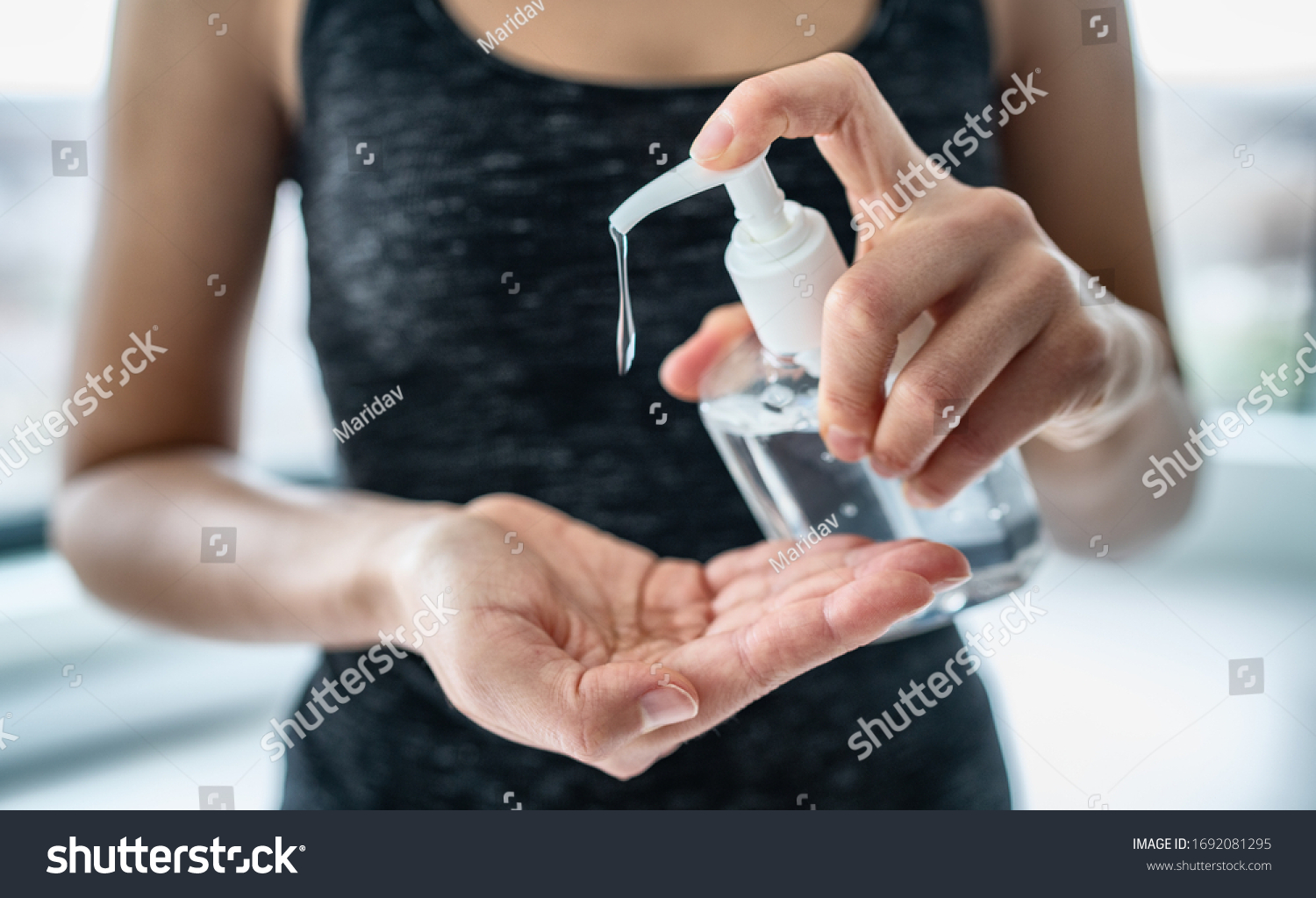Hand sanitizer woman applying sanitizing gel liquid rubbing hands clean personal hygiene coronavirus pervention at home. Sanitiser bottle. #1692081295
