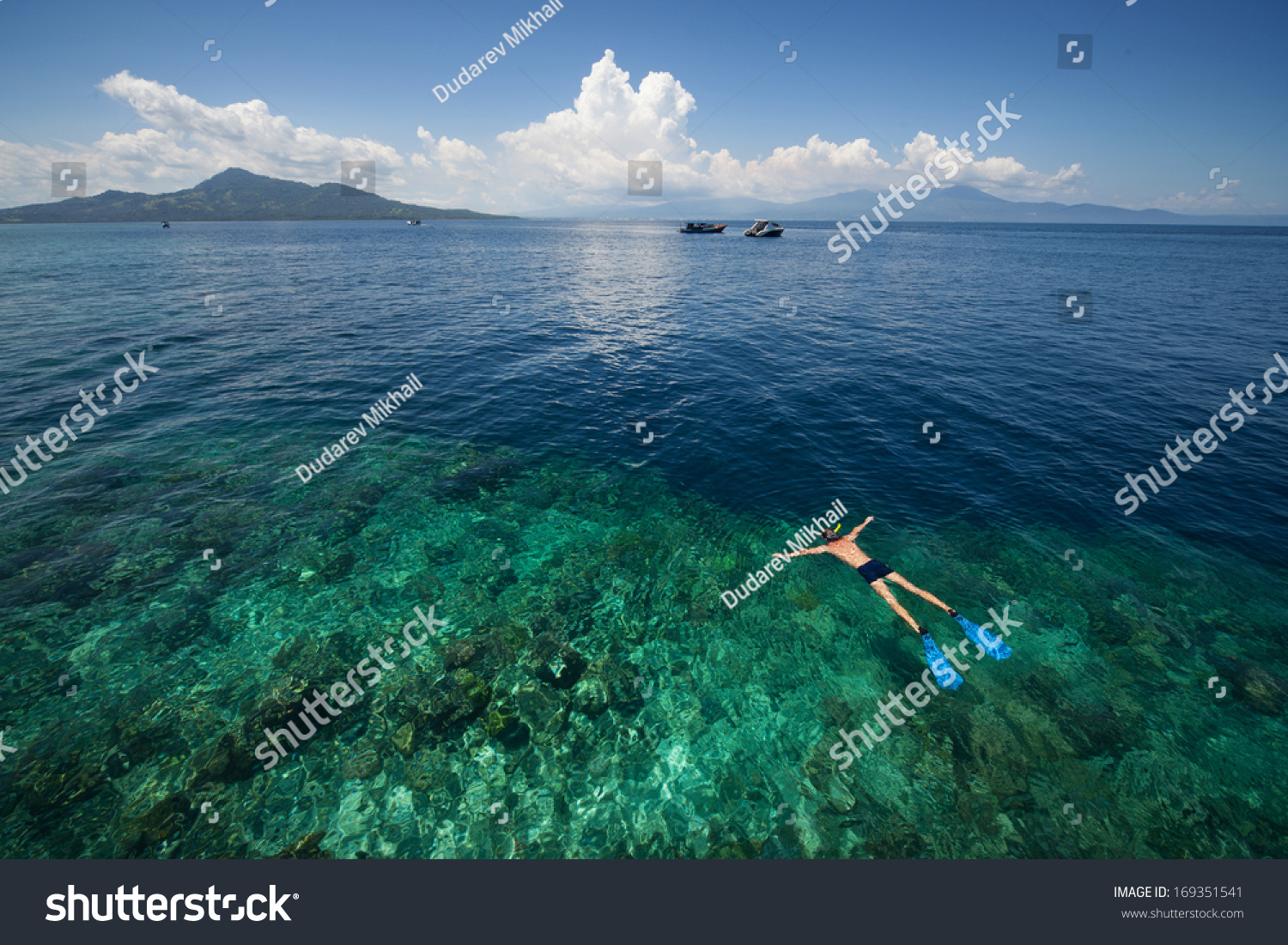 Man snorkeling in a tropical sea by reef's drop off. Indonesia #169351541