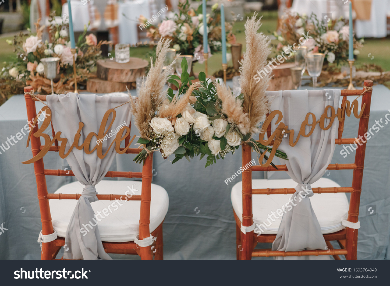 Two chairs assigned to the bride and groom at a wedding setting. Bride and groom. Wedding bride and groom Signs on chairs standing in the woods. #1693764949