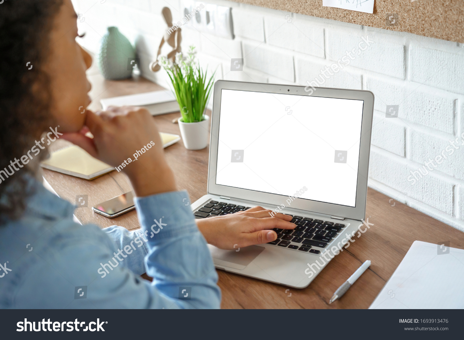African girl student watching video course, distance e-learning, studying with online teacher by webcam. Remote education, work from home concept. Over shoulder close up laptop mock up screen view. #1693913476